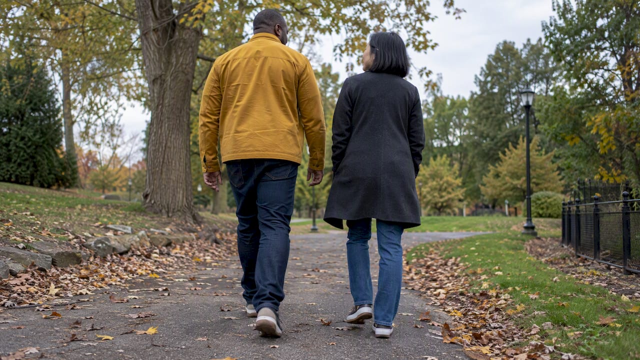 Mixed-race couple walking mindfully in a park